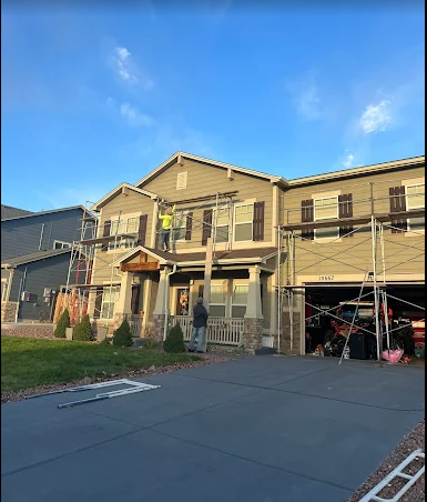 Two-story home being painted with scaffolding